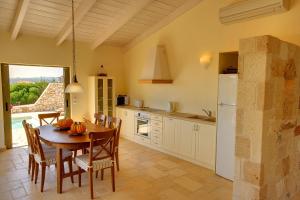 a kitchen with a table and chairs and a refrigerator at Villa Litorina Ideales Resort in Kefallonia