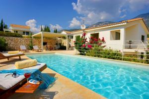 a swimming pool in front of a house at Villa Litorina Ideales Resort in Kefallonia +6 photos