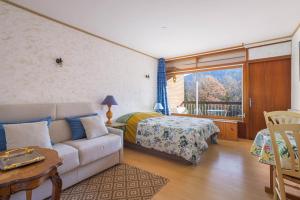 a living room with a couch and a bed and a window at F1 Massif du Canigou in Vernet-les-Bains