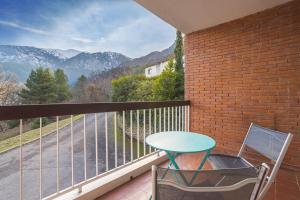 a table and a chair on a balcony with a view at F1 Massif du Canigou in Vernet-les-Bains