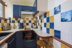 a small kitchen with blue cabinets and a stool at F1 Massif du Canigou in Vernet-les-Bains