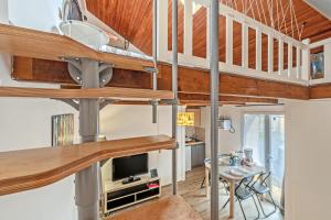 a loft conversion of a house with a living room and dining room at La Gitounette proche Monts d'arrée in Poullaouen