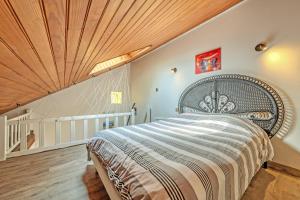 a bedroom with a large bed and a wooden ceiling at La Gitounette proche Monts d'arrée in Poullaouen