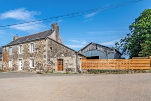 an old stone building with a wooden fence at La Gitounette proche Monts d'arrée in Poullaouen