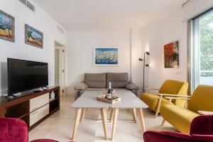 a living room with a couch and a tv at Modern Apartment next the Beach in Marbella