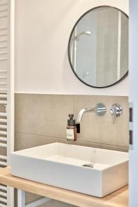 a bathroom with a white sink and a mirror at Alte Seifensiederei - Viktor in Bad Tölz