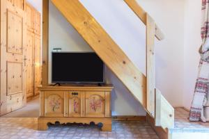a tv sitting on a wooden stand in a room at Casa Lorenz 3 in Canazei