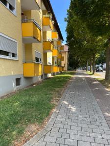 an empty street next to a yellow building at Apartments Neckarsulm in Neckarsulm