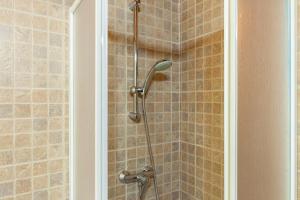 a shower with a shower head in a bathroom at Villaggio Anemone Chalet Fragolina in Capanne di Sillano +20 photos
