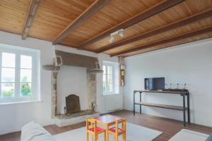 a living room with a fireplace and a table at Ker Ar Vro - Maison atypique in Locquirec
