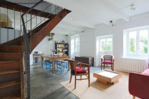 a living room with a staircase and a table and chairs at Ker Ar Vro - Maison atypique in Locquirec
