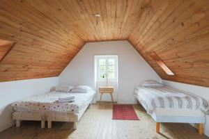 two beds in a room with a wooden ceiling at Ker Ar Vro - Maison atypique in Locquirec