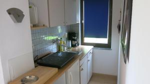 a small kitchen with a sink and a window at Seeblick Ferienbungalow in Leezen