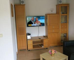 a living room with a tv on a wall at Seeblick Ferienbungalow in Leezen