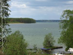 a view of a lake with a boat in the water at Seeblick Ferienbungalow in Leezen