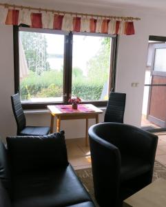 a living room with a table and chairs and a window at Seeblick Ferienbungalow in Leezen