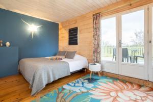 a bedroom with a bed and a large window at Studio - petit déj inclus in Concarneau