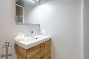 a bathroom with a white sink and a mirror at Studio - petit déj inclus in Concarneau +14 photos
