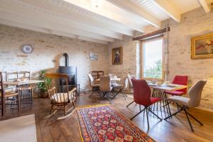 a living room with tables and chairs and a window at Studio - petit déj inclus in Concarneau