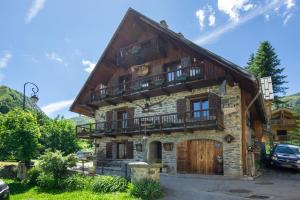 a log house with a balcony on top of it at Chalet Lou Murgis in Saint-Sorlin-dʼArves