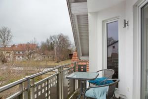 a balcony with a table and chairs and a view at Christines Ferienwohnung in Eitting