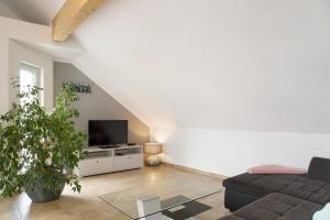 a living room with a couch and a tv at Christines Ferienwohnung in Eitting