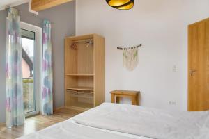 a white bedroom with a bed and a window at Christines Ferienwohnung in Eitting