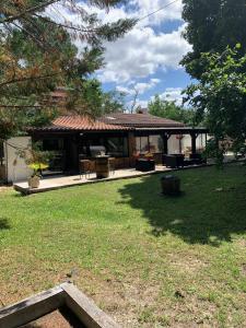 a house with a patio and a yard with grass at Villa Rodolphe in Le Pian-Médoc
