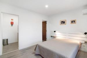 a bedroom with a bed in a white room at Apartamento Nº6 - Sunset in Olhão
