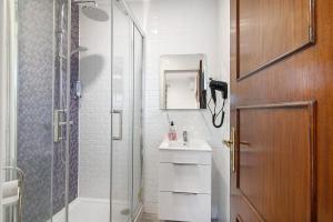 a bathroom with a glass shower and a sink at Apartamento Nº6 - Sunset in Olhão +10 photos