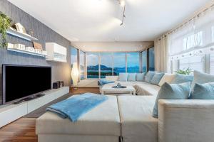 a living room with a large couch and a tv at Connys Ferienwohnungen Sonne in Winsen