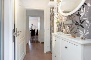 a bathroom with a mirror and a white dresser at Connys Ferienwohnungen Sonne in Winsen +17 photos