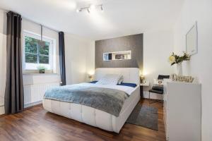 a bedroom with a large white bed and a window at Connys Ferienwohnungen Sonne in Winsen