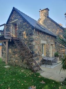 a stone house with a staircase leading to a patio at Au chat qui pêche in Pléguien