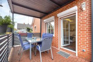 a patio with a table and chairs on a balcony at Connys Ferienwohnungen Sonne in Winsen