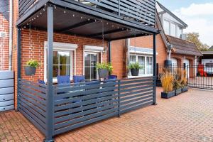 a patio with blue chairs under awning on a house at Connys Ferienwohnungen Sonne in Winsen