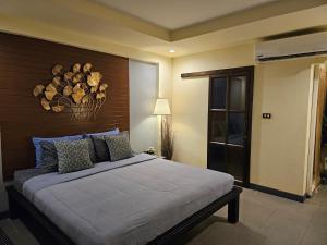 a bedroom with a large bed with a wooden headboard at Baan Baimai Boutique Room in Phra Nakhon Si Ayutthaya