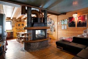 a living room with a large fireplace in a house at Baita Chalet Alabama in Arsiè