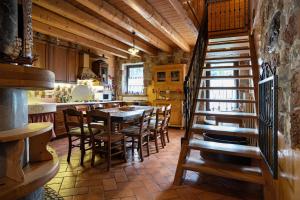 a kitchen with a table and chairs and a staircase at Baita Chalet Alabama in Arsiè