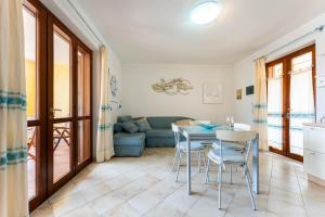 ein Wohnzimmer mit Tisch, Stühlen und Sofa in der Unterkunft Casa Sami in Villasimius