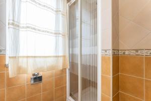 eine Dusche mit Glastür neben einem Fenster in der Unterkunft Casa Sami in Villasimius + 14 Fotos