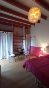 a bedroom with a bed and a table and chairs at Chambres d' hotes Terre Happy in Ribérac