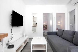 a living room with a couch and a tv at Villa Soleva in Conil de la Frontera