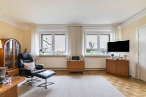a living room with a chair and a flat screen tv at Alte Schule Pahlkrug in Linden