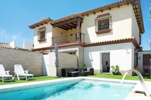 a villa with a swimming pool in front of a house at Villa Soleva in Conil de la Frontera