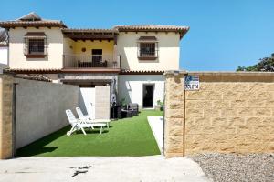 a house with a yard with two lawn chairs at Villa Soleva in Conil de la Frontera