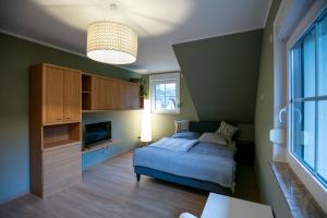 a bedroom with a bed and a television in it at The House Stiller Grund in Hohenfließ