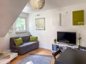 a living room with a couch and a tv at The House Stiller Grund in Hohenfließ