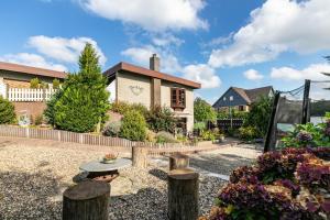 a house with a garden with a table in a yard at Ferienwohnung Hennings in Bargenstedt
