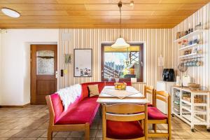 a living room with a red couch and a table at Ferienwohnung Hennings in Bargenstedt